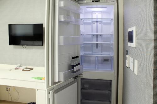 an empty refrigerator with its door open in a room at Ever8 Serviced Residence in Seoul