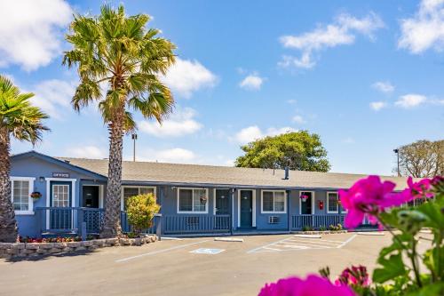 a blue building with palm trees in a parking lot at The Monterey Fireplace Inn in Monterey