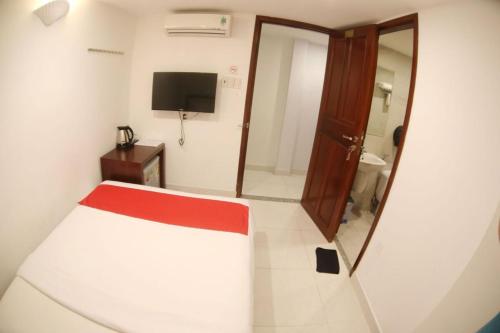 Cette petite chambre comprend un lit et un miroir. dans l'établissement Nu Hotel - 18 Bui Vien Walkstreet, à Hô-Chi-Minh-Ville