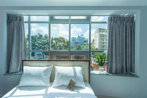 Ce lit se trouve dans un dortoir doté d'une grande fenêtre. dans l'établissement Nu Hotel - 18 Bui Vien Walkstreet, à Hô-Chi-Minh-Ville
