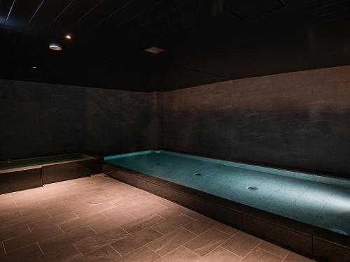 einen Pool in einem dunklen Zimmer mit in der Unterkunft REF Kanku-Izumisano by VESSEL HOTELS in Izumi-Sano