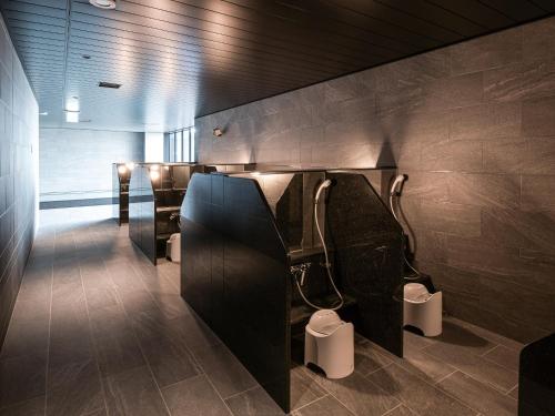 a bathroom with two urinals and toilets on the wall at REF Kanku-Izumisano by VESSEL HOTELS in Izumi-Sano