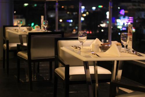 a row of tables with wine glasses in a restaurant at Hotel Ciputra Cibubur managed by Swiss-Belhotel International in Cibubur