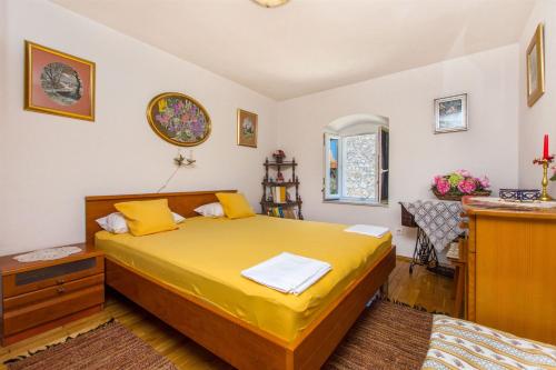 ein Schlafzimmer mit einem gelben Bett in einem Zimmer in der Unterkunft House Stone house in center in Jelsa