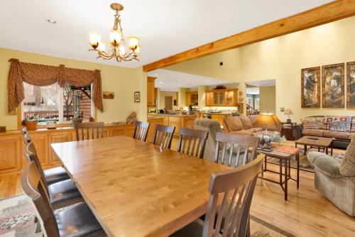 ein Esszimmer und ein Wohnzimmer mit einem Holztisch und Stühlen in der Unterkunft Fawnskin Log Cabin- Luxurious Group Log Cabin Estate- Hot Tub- Walk to Lake in Fawnskin