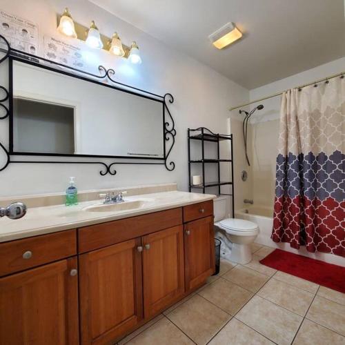 a bathroom with a sink and a toilet and a mirror at Amazing palm villa house in Riverside