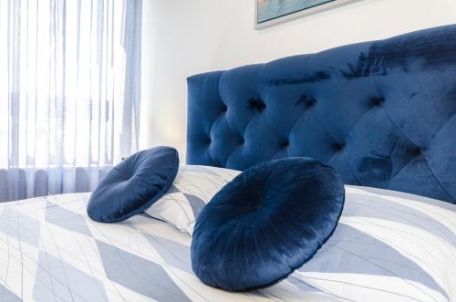 Una cama con dos almohadas azules encima. en Apartments Ella en Vodice