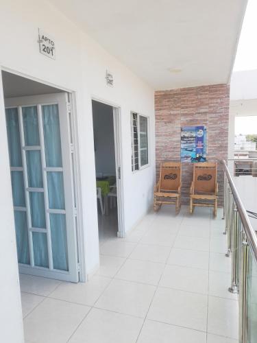 a corridor of a building with two chairs and a balcony at Apartamentos LUISA in Coveñas