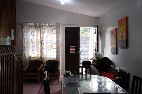 een woonkamer met een tafel en een persoon op een bank bij 4 Bedroom Apartment 15pax Moran in Baguio