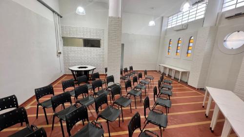 ein leeres Zimmer mit Stühlen, Tischen und einem Tisch in der Unterkunft Hotel Uirapuru in Araraquara
