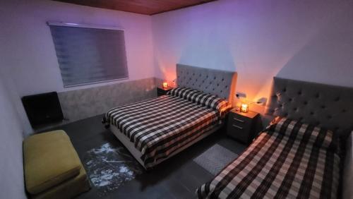 a bedroom with two beds and a chair and lights at Departamento por día in Río Gallegos