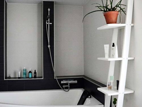 a bathroom with a bath tub and a sink at Holiday home Halmstad VII in Halmstad