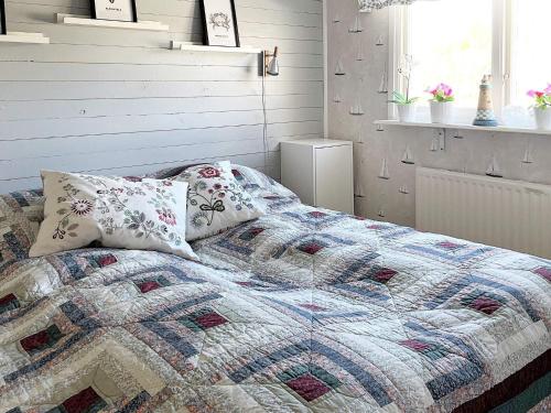- un lit avec une couette et des oreillers dans une chambre dans l'établissement Holiday home LJUNGSKILE VI, à Ljungskile