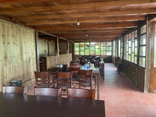 ein Esszimmer mit Tischen, Stühlen und Fenstern in der Unterkunft Lagom Bắc Hà Farmstay in Lào Cai