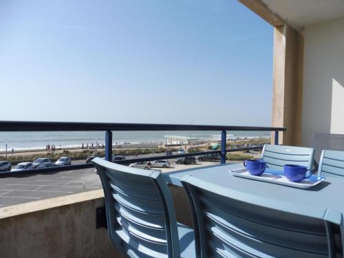 - une table avec des chaises et une vue sur la plage dans l'établissement Notre-Dame-de-Monts - Appartement 28m² avec balcon - 2 pers, parking privé - FR-1-540-211, à Notre-Dame-de-Monts