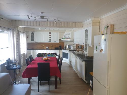 a kitchen with a red table with chairs and a refrigerator at Holiday Home in Gol