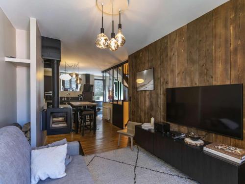 un salon avec une grande télévision à écran plat dans l'établissement Maison spacieuse au centre de Cauterets, avec terrasse, garage, et proche commodités et télécabines. - FR-1-401-260, à Cauterets