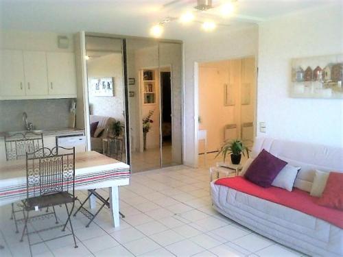 un salon avec un canapé et une cuisine dans l'établissement Appartement moderne à Ciboure avec piscine et vue exceptionnelle - FR-1-4-673, à Ciboure