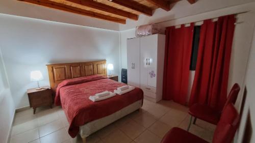 1 dormitorio con cama roja y cortina roja en DEPARTAMENTO Matrimonial Glaciar Martial en Ushuaia