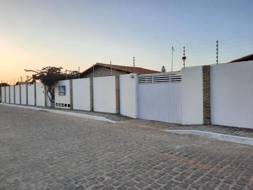 a row of white fences on the side of a street at Chalés Pipa Brasil in Pipa