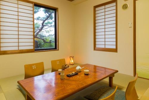 a dining room with a wooden table and chairs at スイートヴィラ 箱根強羅 in Gora