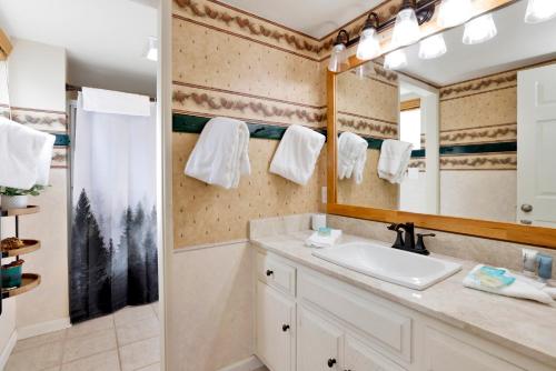 a bathroom with a sink and a mirror at Tinker Bell Gambrel by Big Bear Vacations Ultra Relaxing Bear City Retreat in Big Bear City