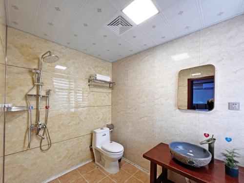 a bathroom with a toilet and a shower and a sink at Yijingju Humanistic Inn in Zhangjiajie