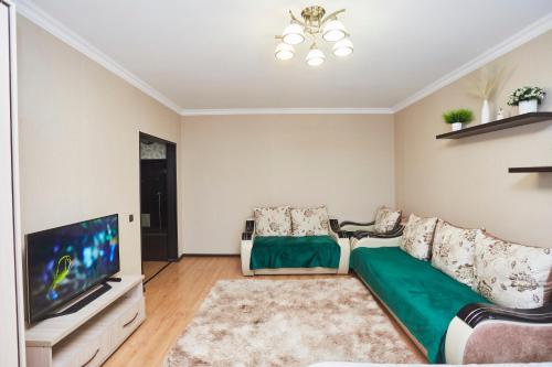 a living room with a couch and a flat screen tv at Просторная 1ком квартира у Набережной Астаны in Astana
