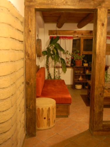 a living room with a red couch and a stool at La Troje de Adobe in Creel