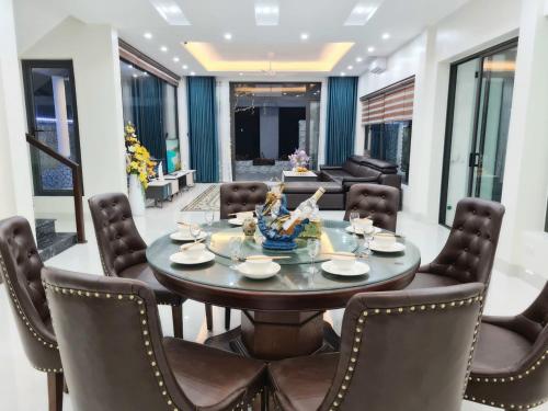 a dining room with a round table and chairs at Villa FLC Sam Son Lavender in Sầm Sơn