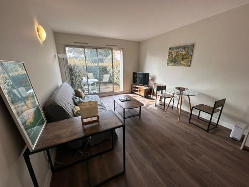 un salon avec un canapé, une table et des chaises dans l'établissement Studio cosy à 150m de la Plage de Nauzan avec jardin privatif et parking, Vaux-sur-Mer - FR-1-550-52, à Vaux-sur-Mer