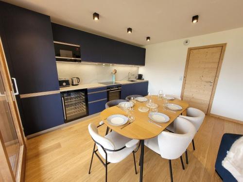une cuisine et une salle à manger avec une table et des chaises en bois dans l'établissement Spacieux duplex 3 chambres en suites, proche pistes et navettes, Les Gets - FR-1-598-140, aux Gets