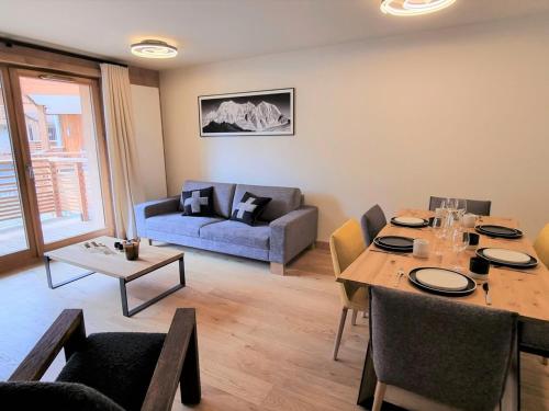 un salon avec une table et un canapé dans l'établissement Appartement 6 pers avec terrasse au cœur du village, résidence neuve avec sauna et parking - FR-1-598-141, aux Gets