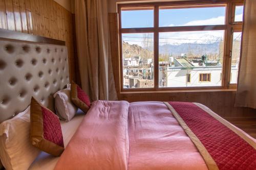 sypialnia z łóżkiem i dużym oknem w obiekcie Laksdup Guest House w mieście Leh