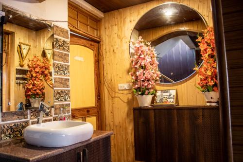 W łazience znajduje się umywalka i lustro. w obiekcie Laksdup Guest House w mieście Leh