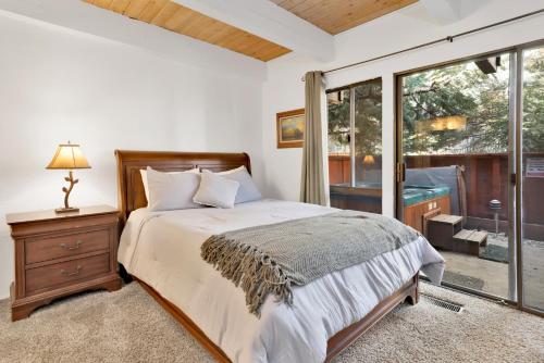 a bedroom with a bed and a window at Slopeside Views Chalet- Hot Tub- Resort View Cozy Condo in Big Bear Lake