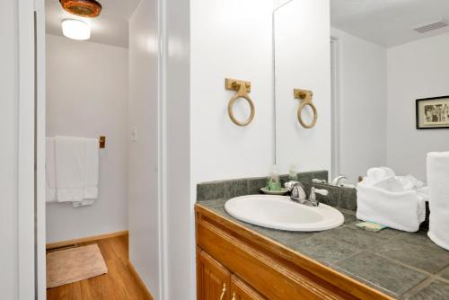 a bathroom with a sink and a mirror at Slopeside Views Chalet- Hot Tub- Resort View Cozy Condo in Big Bear Lake