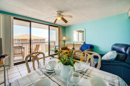 a dining room with a table with flowers on it at Bright Carolina Beach Condo Public Beach On-Site in Carolina Beach