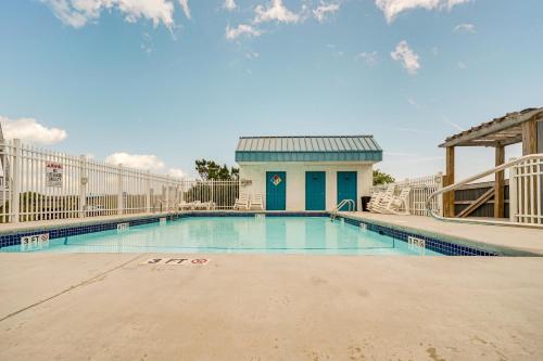 a swimming pool with a building in the background at Bright Carolina Beach Condo Public Beach On-Site in Carolina Beach