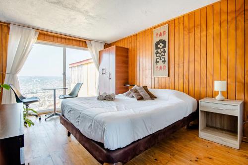 ein Schlafzimmer mit einem großen Bett und einem Tisch mit Stühlen in der Unterkunft Casa Altavista in Valparaíso