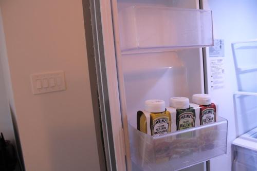 a refrigerator filled with lots of bottles of mustard at Modern Town House Barrie South in Barrie