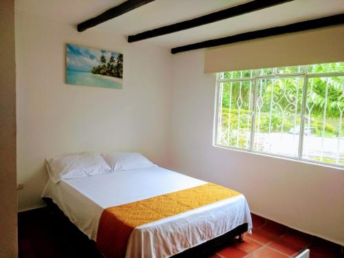 um quarto com uma cama e uma janela em Hotel Playa By Marbar em Villeta