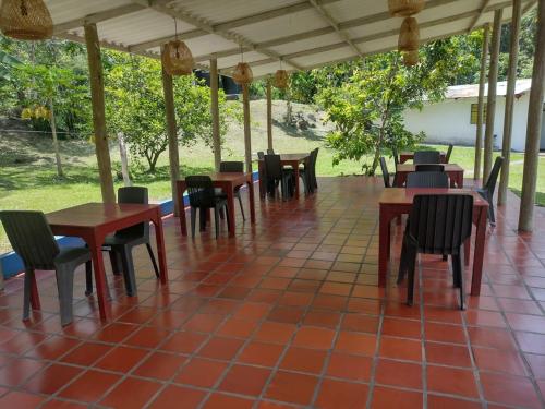 a restaurant with tables and chairs on a tiled floor at Hotel Playa By Marbar in Villeta