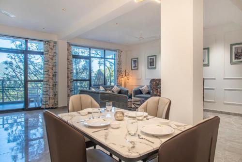 ein Esszimmer mit einem Tisch und Stühlen in der Unterkunft Mystic Hill Crest Luxurious 2 BHK Apartments in Kasauli