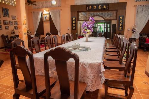 uma sala de jantar com uma mesa longa e cadeiras em บ้านกิจเสรี 