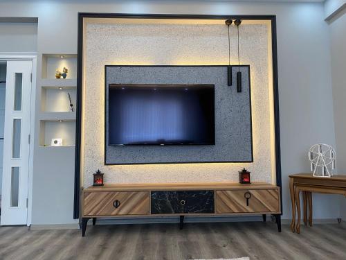 uma sala de estar com uma grande televisão na parede em CMH em Rize