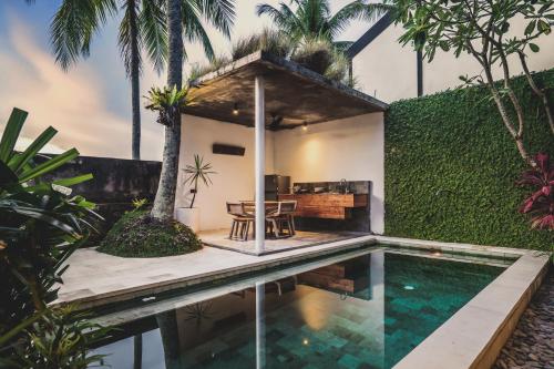 a villa with a swimming pool and a house at The Saren in Tanah Lot