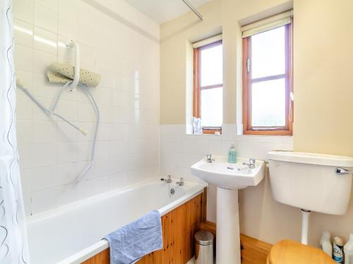 a bathroom with a sink and a bath tub and a toilet at Water Hall Cottage in Chelsworth