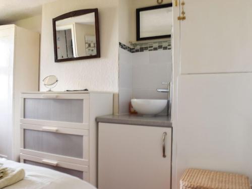 uma pequena casa de banho com um lavatório e um espelho em Cosy Cottage em Allonby