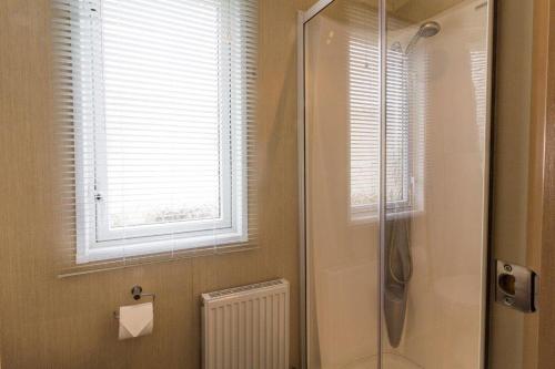 a bathroom with a shower and a window and a shower at Luxury Caravan Boasting Full Sea Views At Hopton Holiday Park Ref 80041s in Great Yarmouth